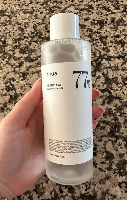 A reviewer holding a bottle of the toner.