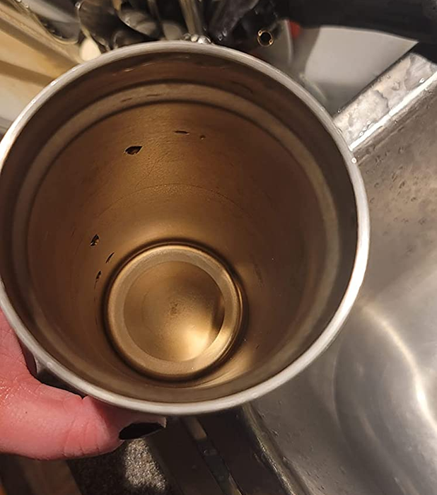 Reviewer holding a thermos with coffee stains