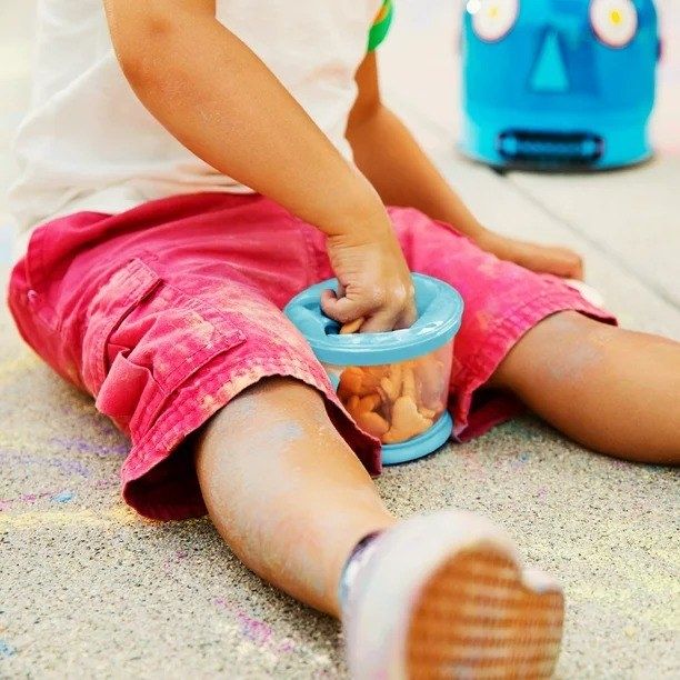 A child happily using a snack container.