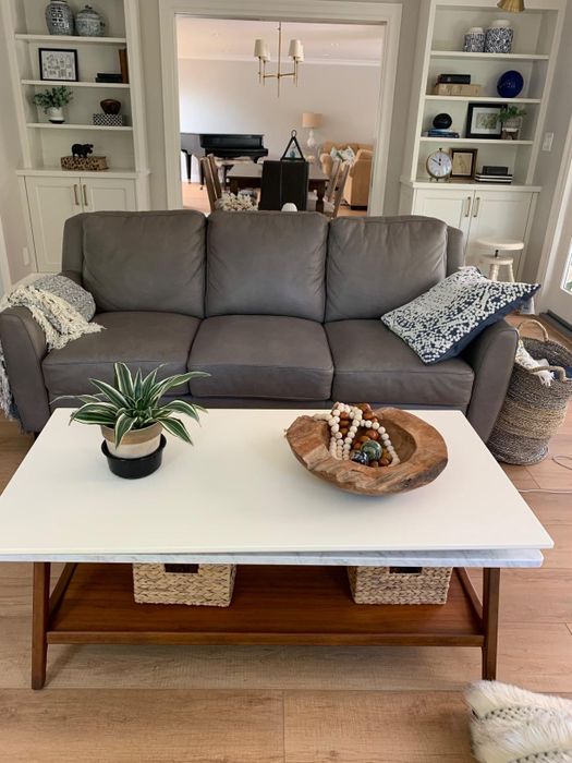A reviewer's white mid-century modern table adorned with decor items on top.