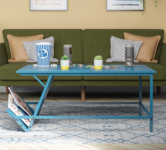 The table in blue with magazines neatly placed in the integrated rack.