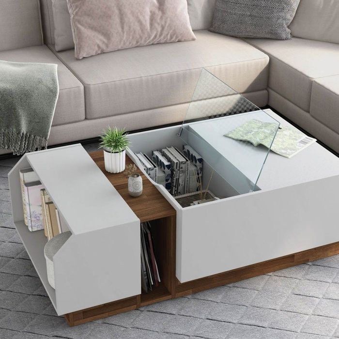 A coffee table featuring a side shelf and an inner compartment with an open glass lid.