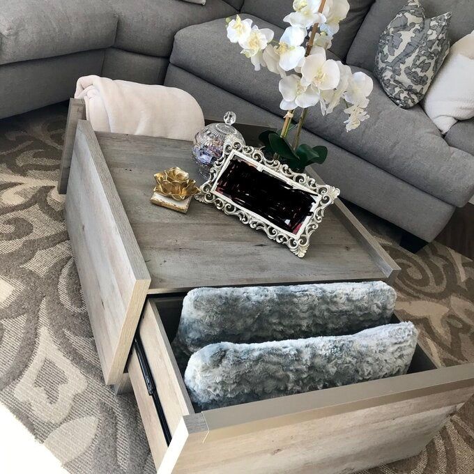 A reviewer photo of the coffee table with drawers filled with cozy blankets.