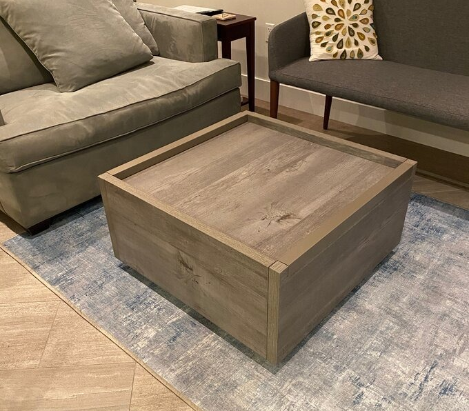 A reviewer photo showing the table in a warm light brown finish.