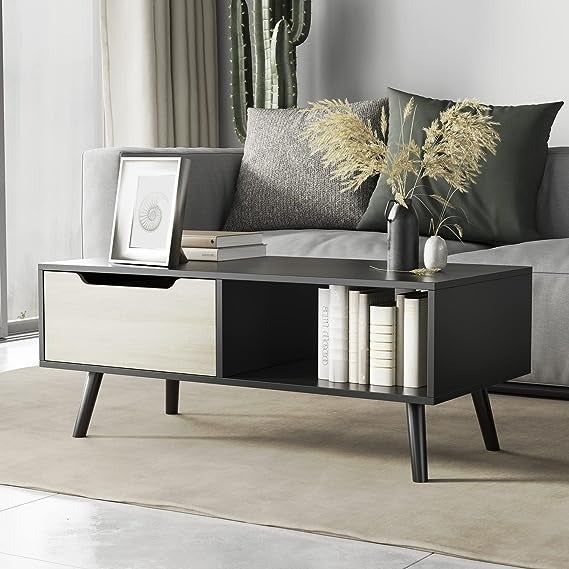 A black coffee table with a contrasting white drawer, offering a stylish and functional design.