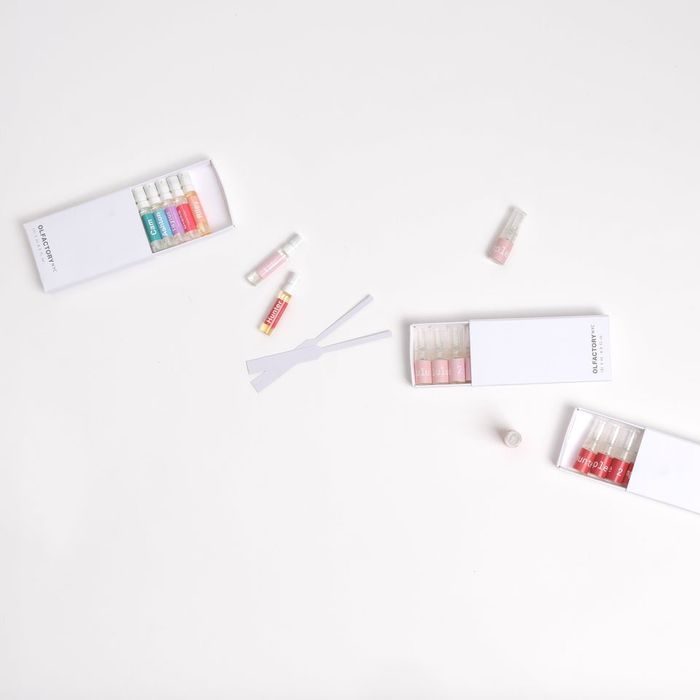 Flat lay of various perfume sample vials and boxes on a white backdrop, carefully arranged for a shopping article focused on fragrance discovery sets