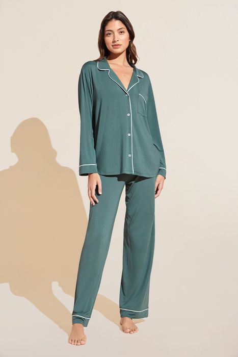 A person wearing a cozy, long-sleeved pajama set with a button-up top, perfect for a sleepwear shopping feature.