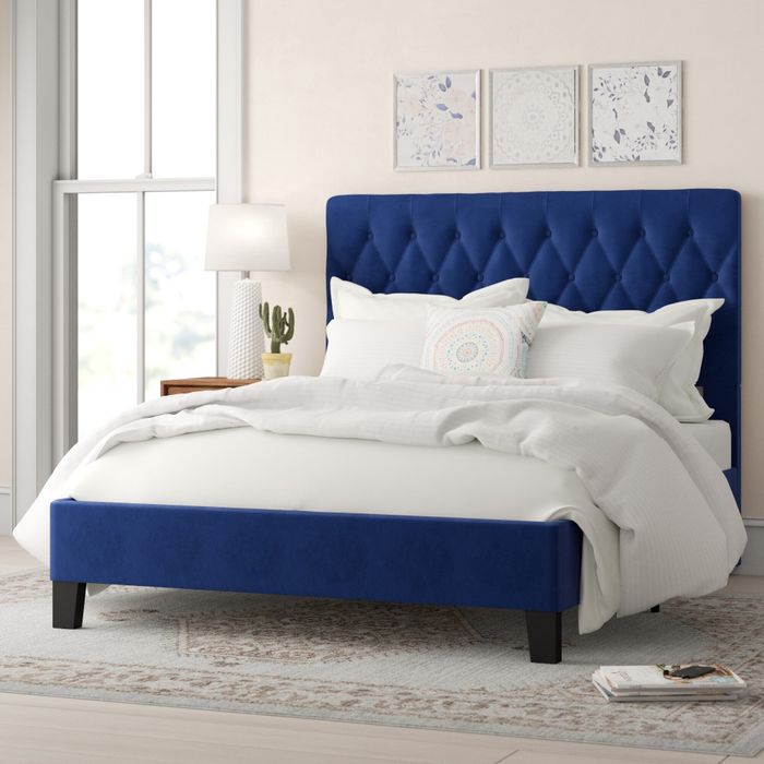 the blue tufted bed with crisp white bedding