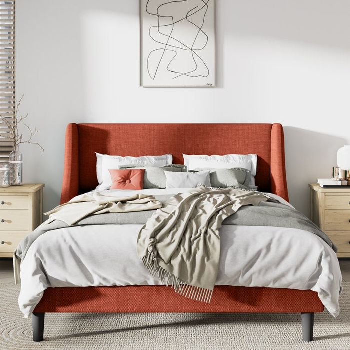 An upholstered orangey platform bed