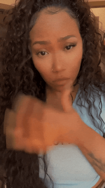 A gif of me styling a wavy synthetic wig.