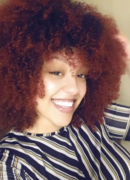 A reviewer showcasing their defined coily hair.