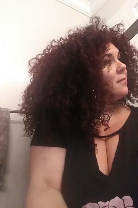A woman showcasing her curly hair after using the blow dryer with the diffuser attached