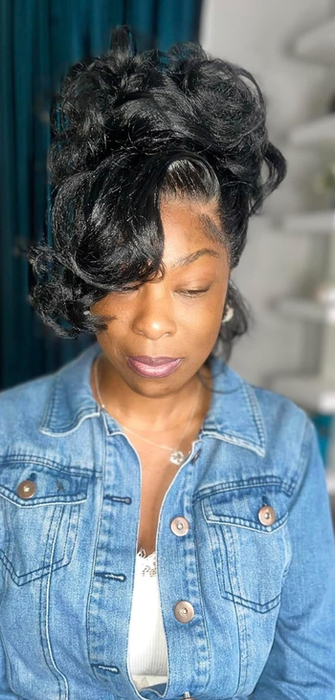 A reviewer rocking a black wig styled in a chic updo.