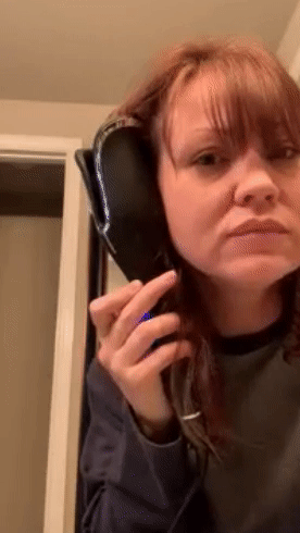 A reviewer using a curling iron to style their hair.