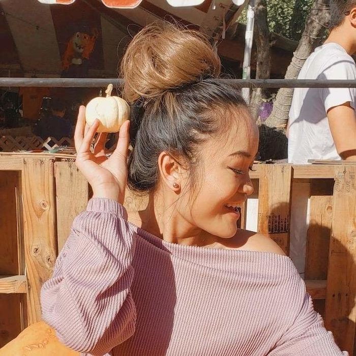 A model rocking a messy bun in a rich toffee brown shade.