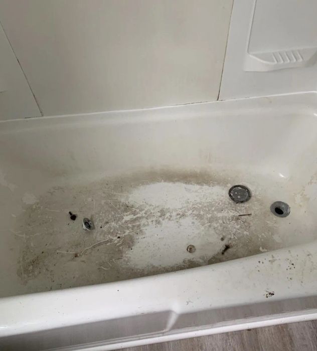 Before the shower was cleaned, with dirt and grime visible on the tiles.