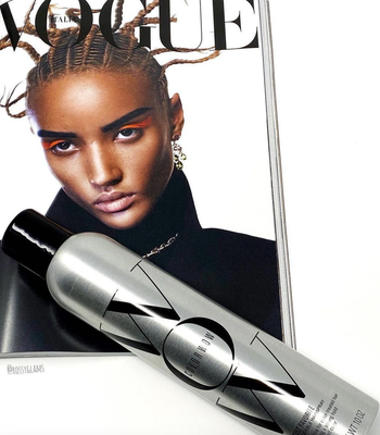 the silver can of hairspray resting on a Vogue magazine