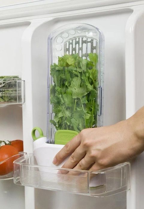 Fridge door shelf featuring a vertical storage unit designed to keep herbs fresh inside.