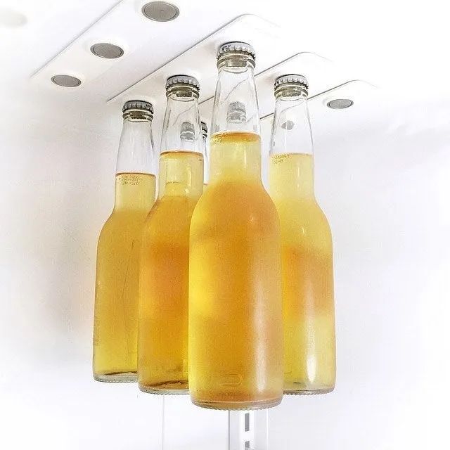 Inside view of a fridge's roof with magnetic strips strong enough to hold beer bottles, leaving ample room below for extra storage.