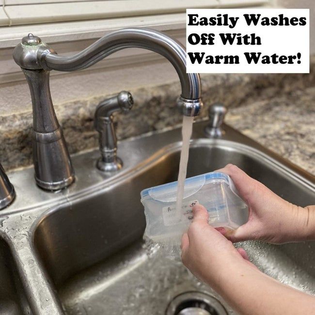Person removing a label from a container under running water