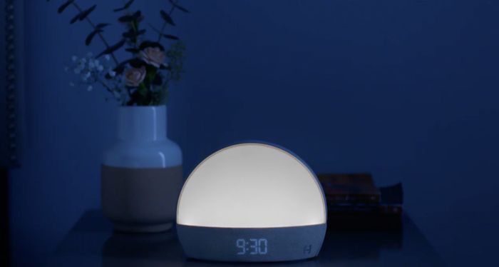 The alarm clock displaying 9:30 and softly glowing white in a dark room