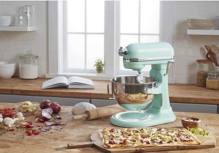 The turquoise mixer being used to knead pizza dough