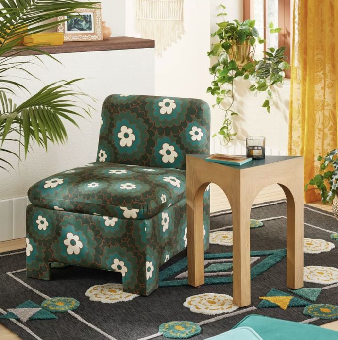 The low-profile upholstered chair positioned beside an accent table