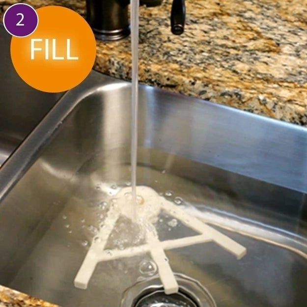 Water filling a sink with dishwasher-safe components submerged inside. The words 