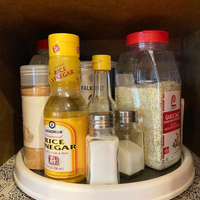 A selection of pantry essentials like rice vinegar, garlic salt, and various seasonings neatly organized on a rotating tray