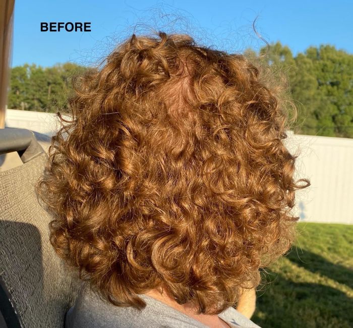 A photo of the reviewer’s hair before applying the TGIN mousse, displaying natural curls that need some definition.