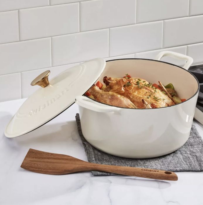 A white casserole dish filled with roast chicken and vegetables, sitting on the kitchen counter.