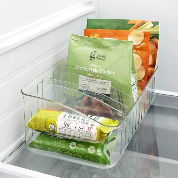 A fridge bin holding packages of homestyle turkey meatballs and organic sweet peas.