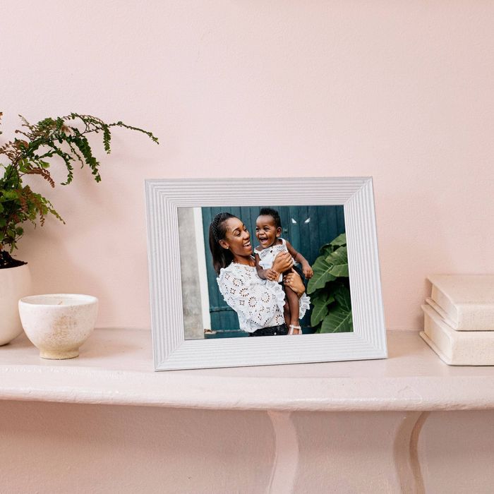 The white-framed photo display showcasing an image of a mother and her toddler