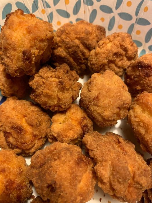 A plate of golden, crispy fritters fresh out of the air fryer.