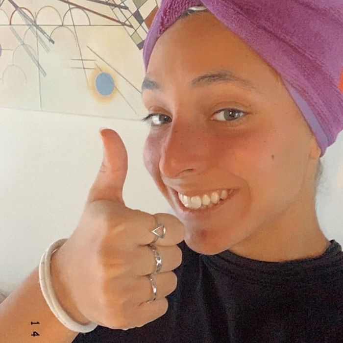 The reviewer gives a thumbs-up while wearing the microfiber hair towel, showcasing how easy it is to use.