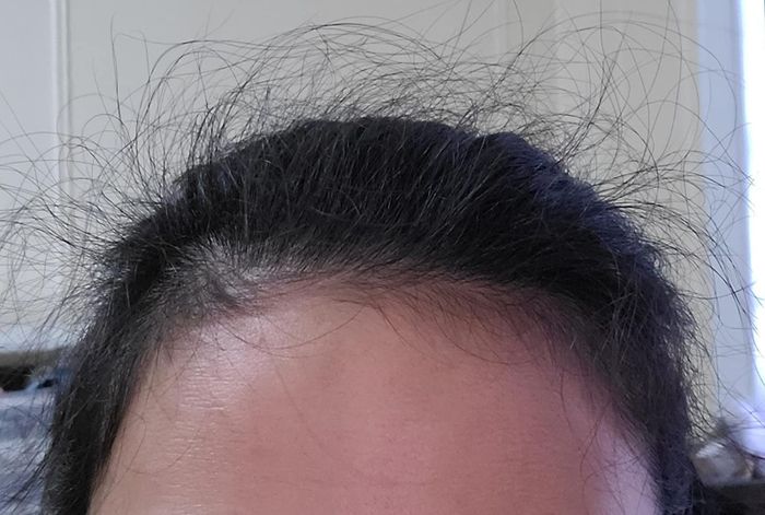 The reviewer's hair before using the finishing stick had some noticeable flyaways and unruly cowlicks.