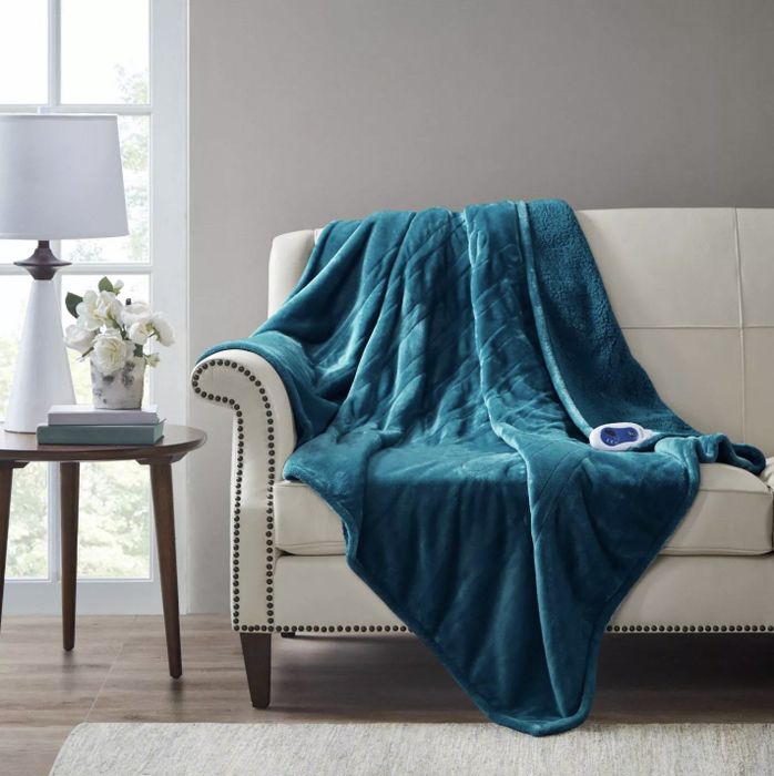 The cozy blue throw blanket draped over the back of a couch