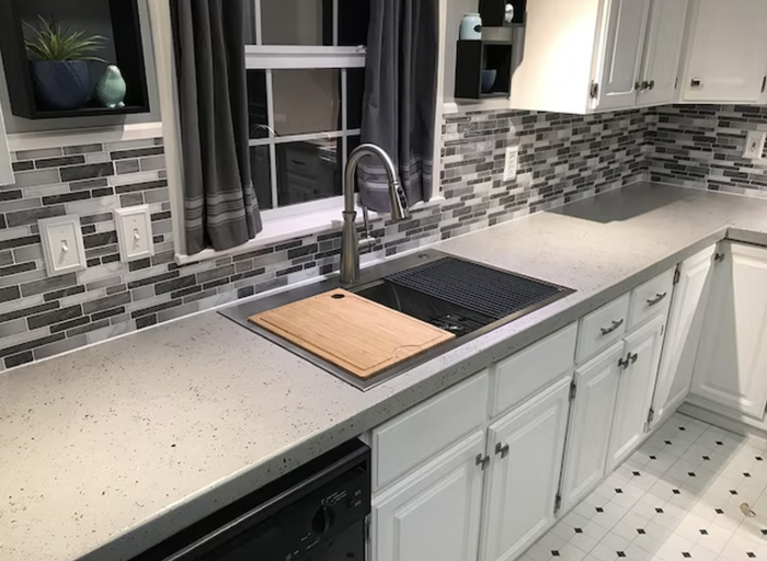 Remodeled white kitchen countertop, positioned next to the sink and cabinets