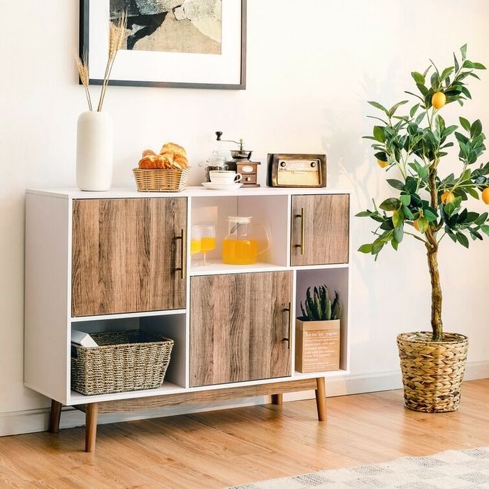 A cabinet with a coffee maker and speaker placed on top, while the storage cubbies are filled with various miscellaneous items.
