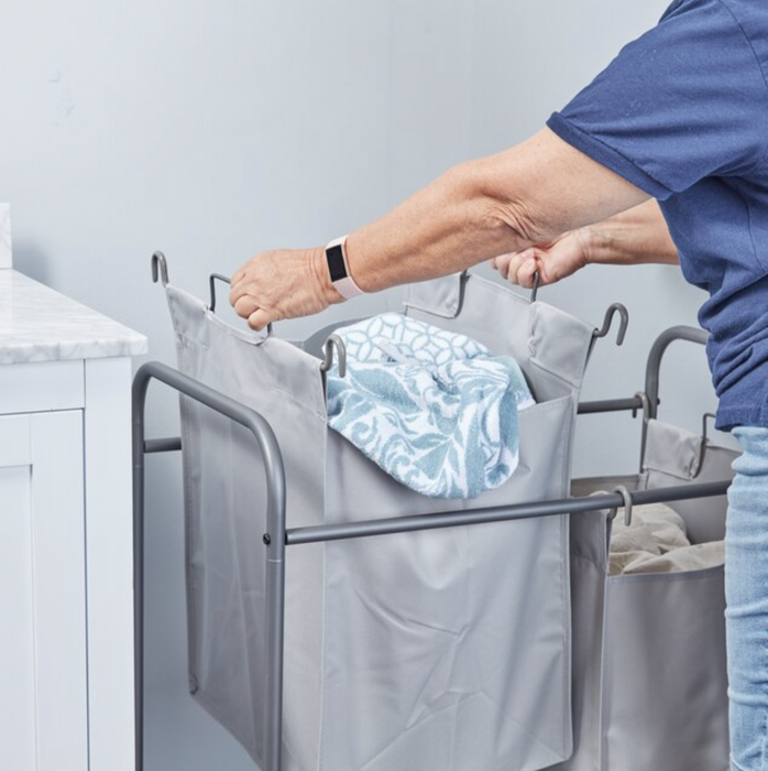 A model lifting one of the laundry bags from the cart