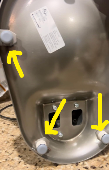The underside of a kitchen mixer with appliance sliders attached for easy movement.