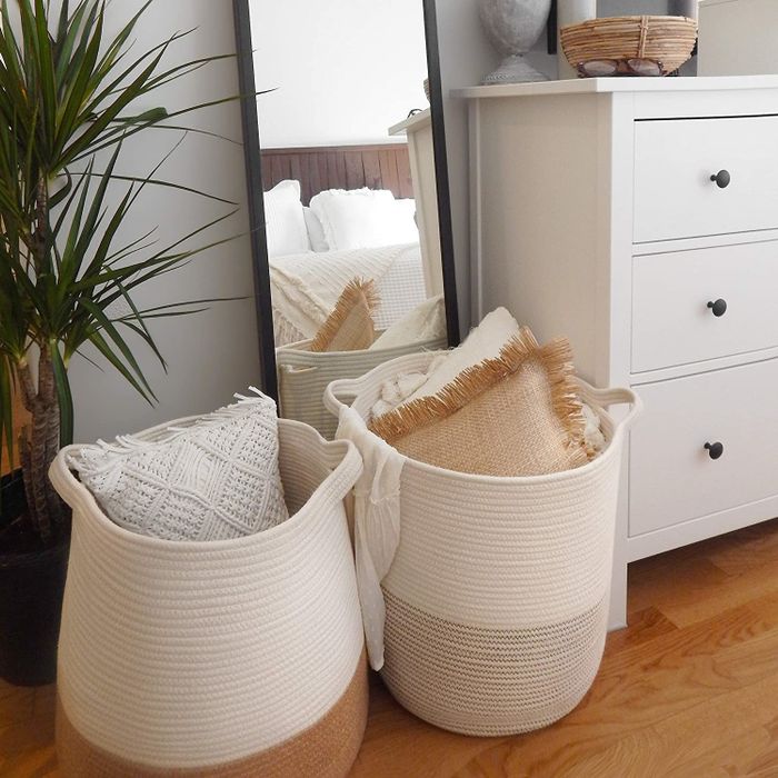 A photo of two woven baskets filled with pillows and blankets, adding a cozy and organized touch.
