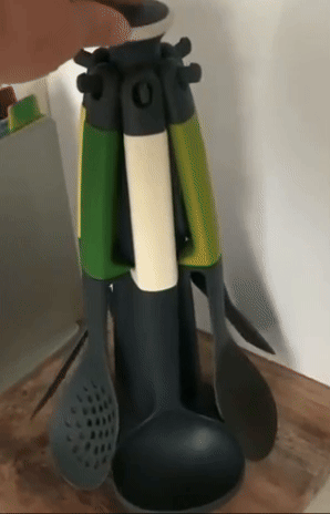 A variety of kitchen utensils rotating on a carousel holder.
