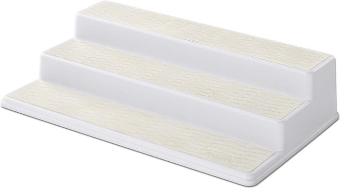 A white three-tier riser display stand with textured surfaces for showcasing your items