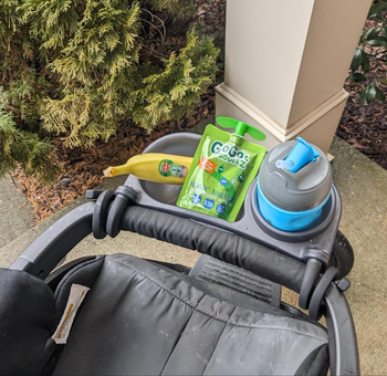 A stroller tray featuring a banana and a GoGo squeeZ applesauce pouch.