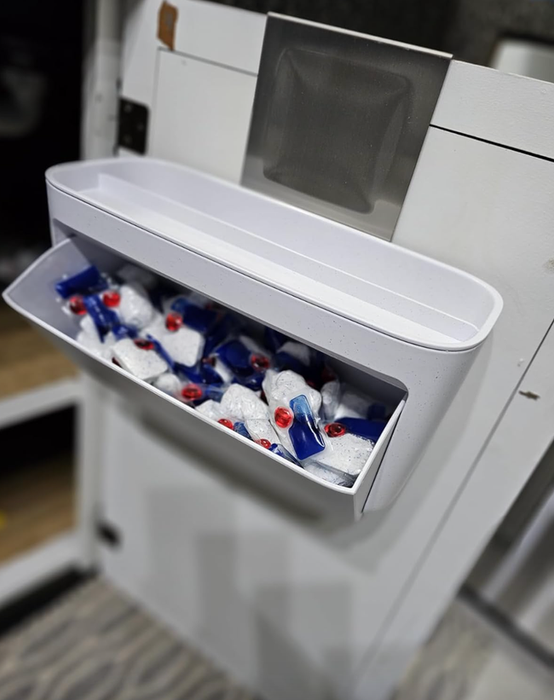 A freezer drawer is open, revealing neatly packed ice packs inside.