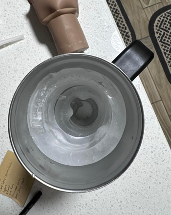 A water bottle filled with a large cylindrical ice block, seen from above.