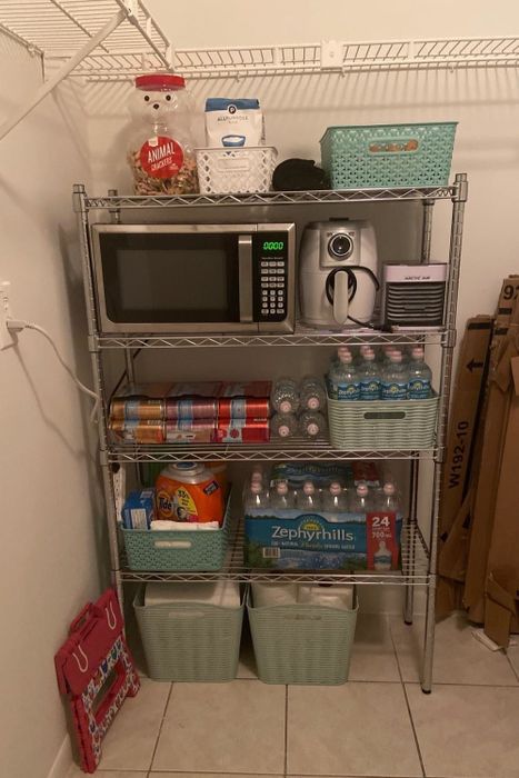 A reviewer shares a photo of the shelving unit in their kitchen, complete with a microwave and food stored neatly on it.
