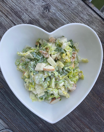 A Caesar salad served in a heart-shaped bowl.