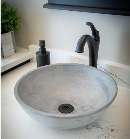 A bathroom sink basin paired with a sleek modern faucet and soap dispenser, all resting on a luxurious marble countertop.